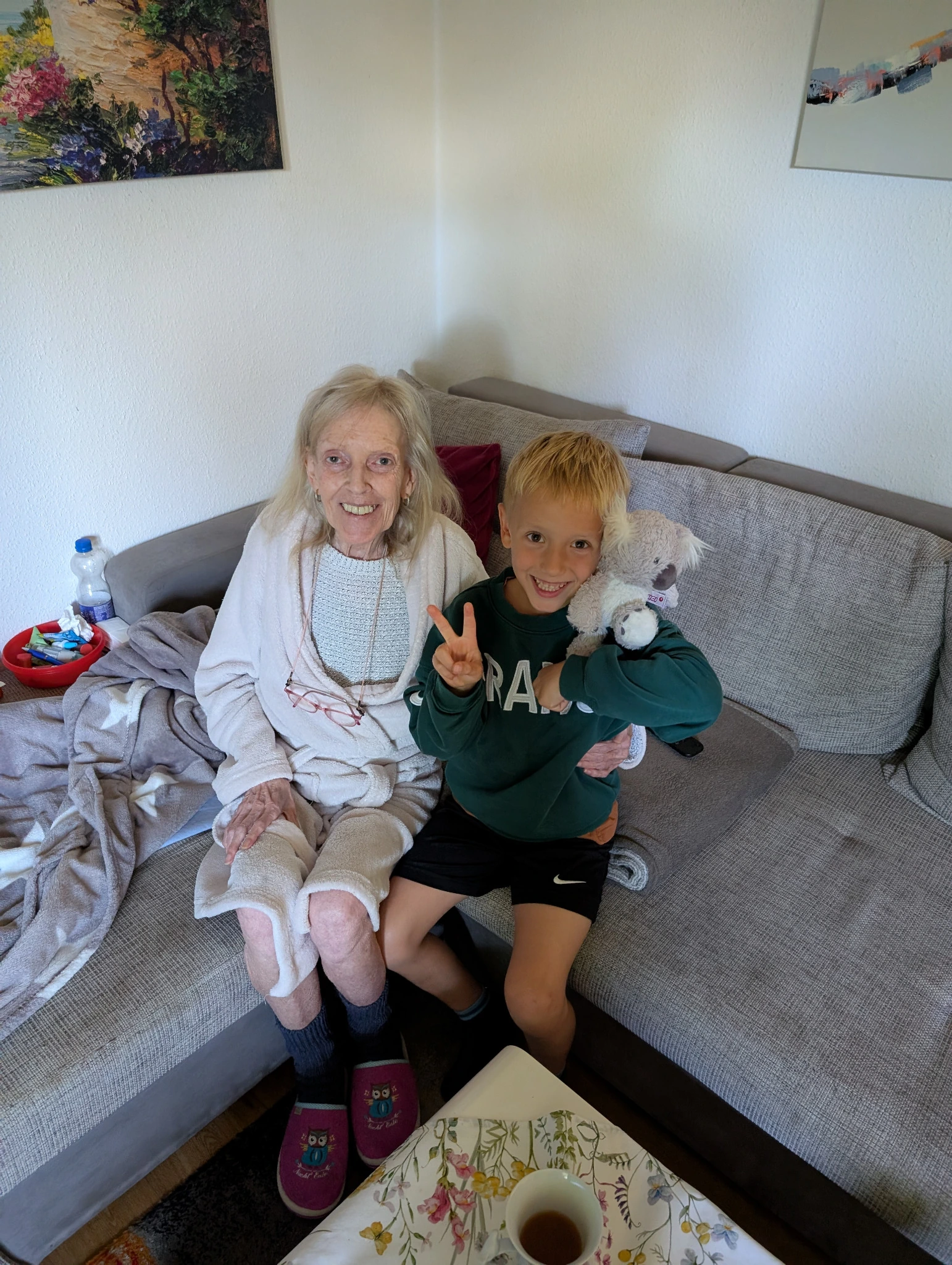 Oma und ihr Enkel sitzen zusammen auf dem Sofa.